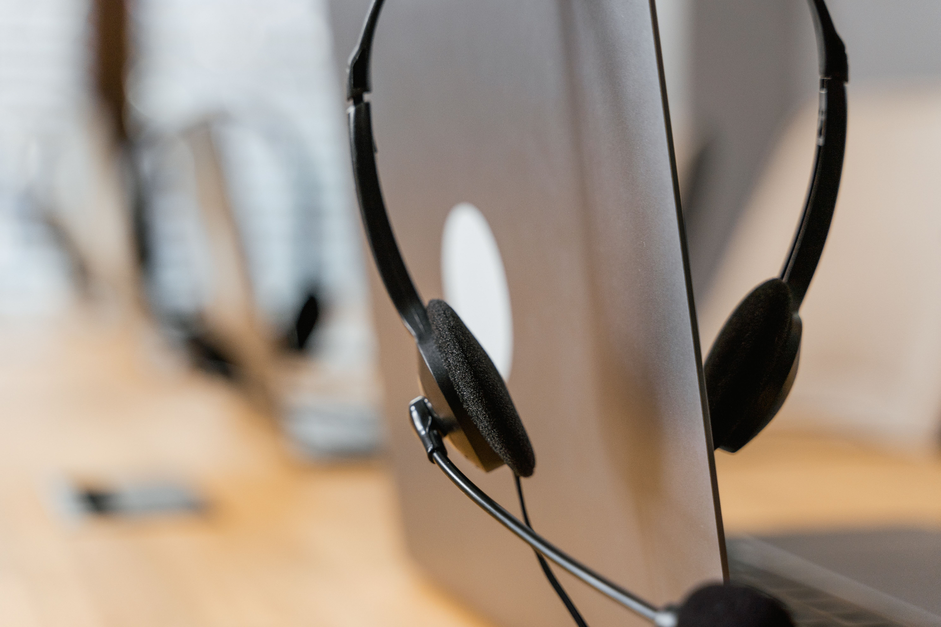 Close-up of a support headset resting on a monitor at a helpdesk station
